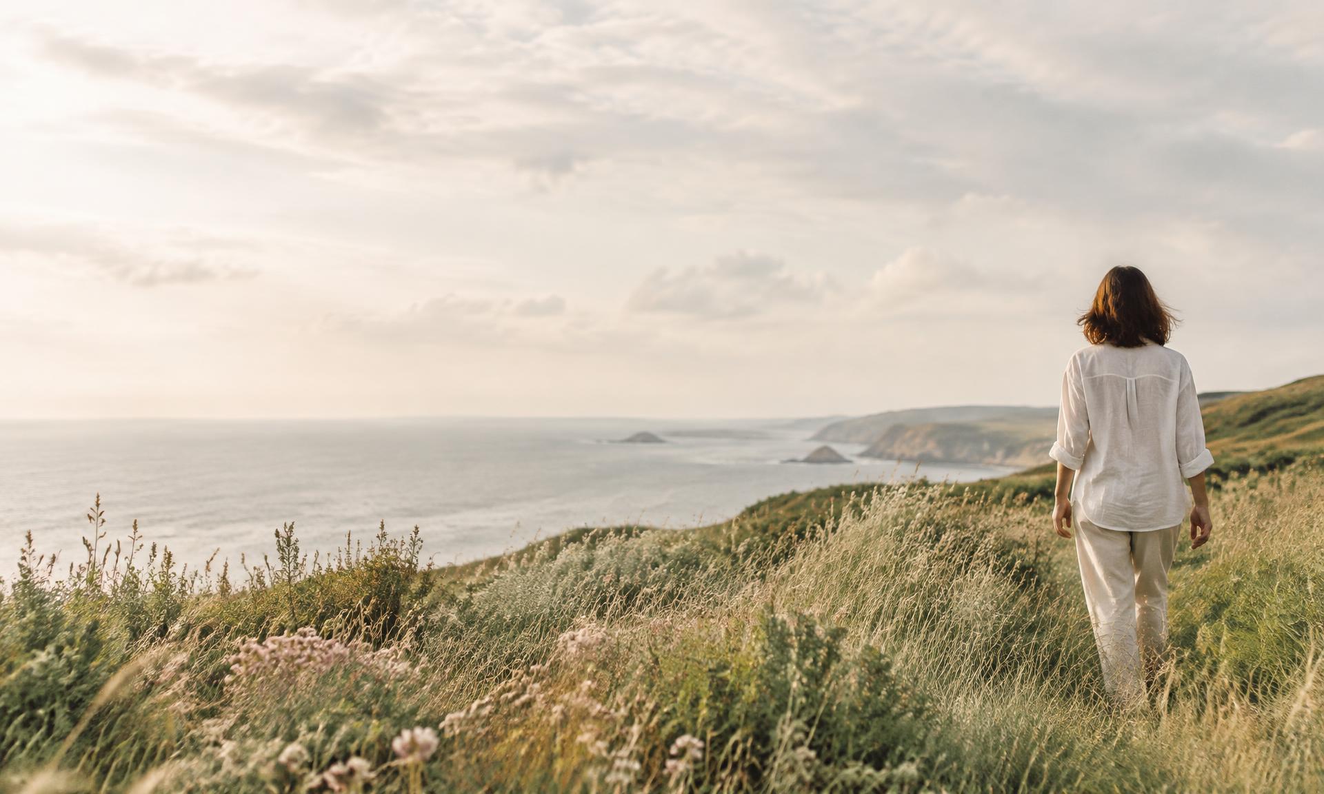 A woman taking a quiet walk through a coastal wildflower meadow